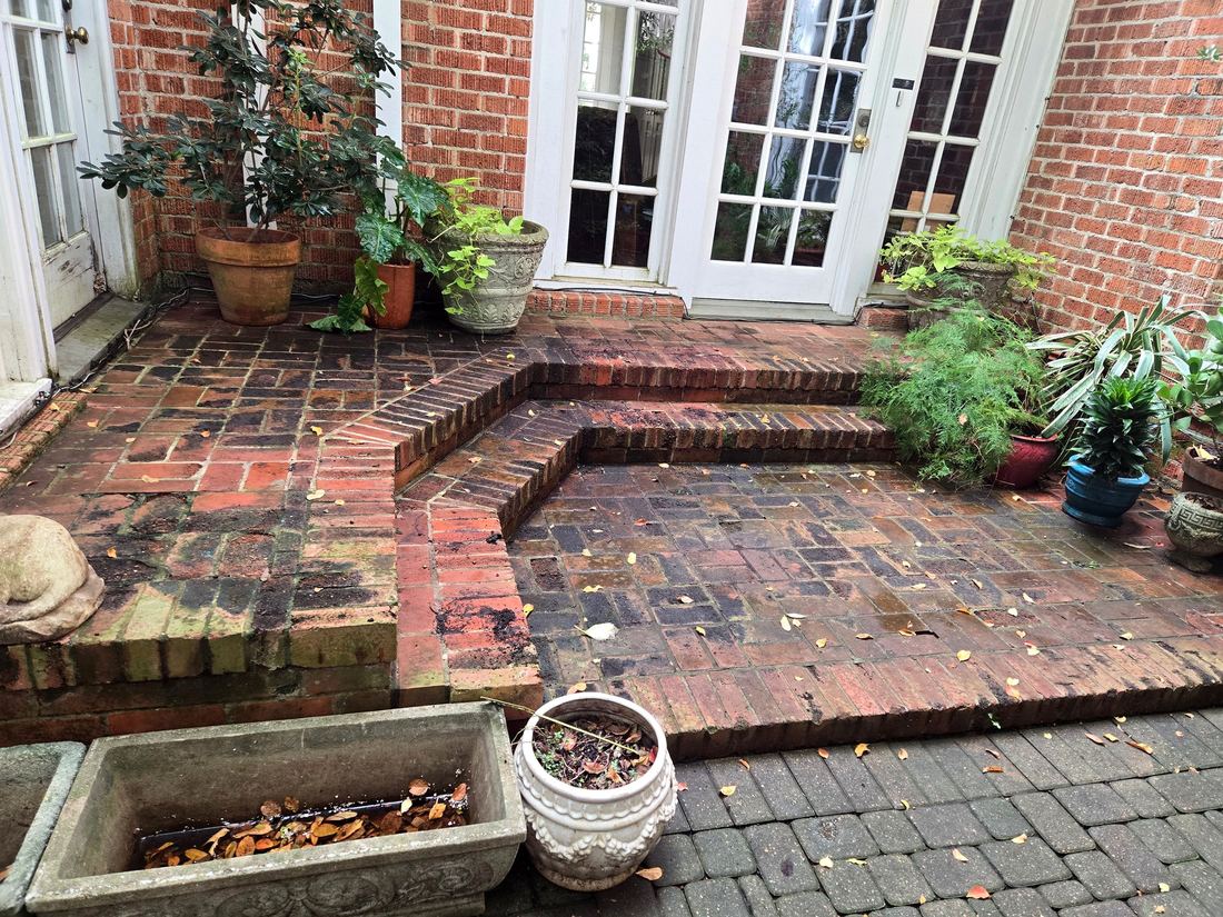 Brick courtyard before cleaning — dark with moss and grime