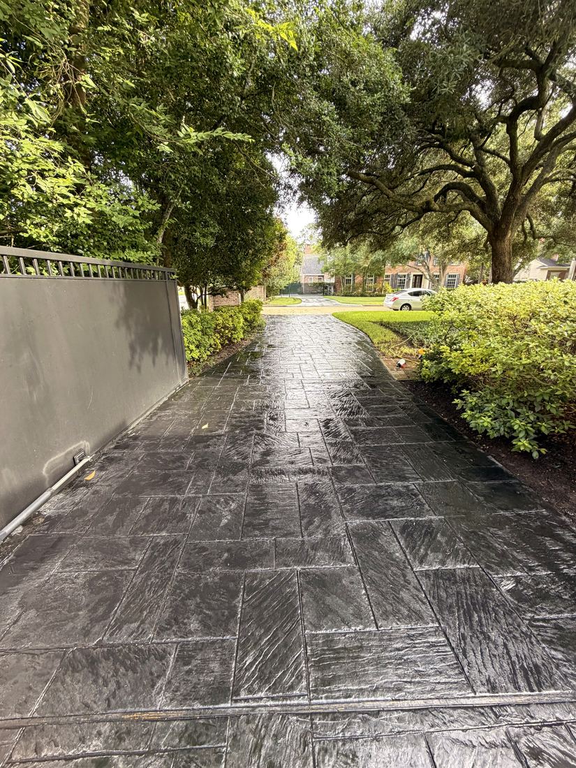 The same stamped driveway after our wash and protective treatment — rich slate-black restored