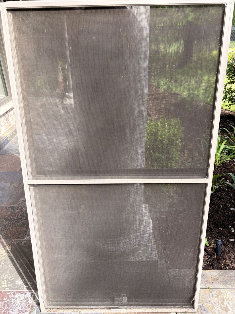 Window screen caked with dust and pollen — before our Xero screen cleaning